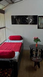 a bedroom with a bed and a table in it at Tropical Whisper in Nagaon