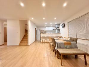 a dining room and kitchen with a table and chairs at Furano U Plus in Furano