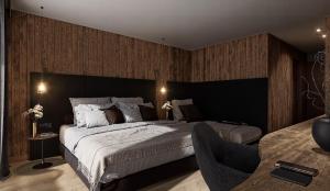 a bedroom with a large bed and a chair at Villa Erina in Ortisei