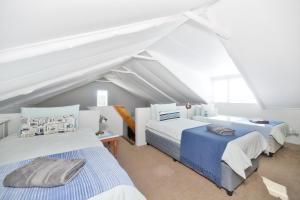 two beds in a room with a attic at Hugo Haven in Bredasdorp