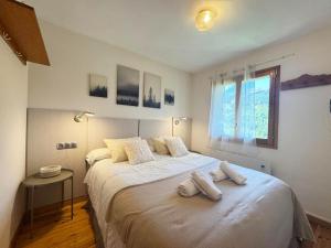una camera da letto con un letto grande con due asciugamani sopra di C09 - Apartamento Pirineos - Villmor a Cerler