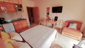 ein Schlafzimmer mit Bett und eine Küche mit Tisch in der Unterkunft Студио PANORAMA MOUNTAIN, до ски писта Пампорово-Стойките in Stoykite + 40 Fotos