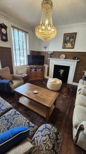 a living room with a coffee table and a chandelier at Beautiful 4BR Georgian house in Wisbech