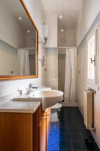 a bathroom with a sink and a toilet and a mirror at Camere con bagno privato in APT condiviso Palazzo Pitti in Florence