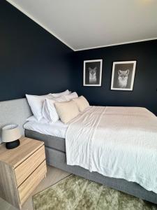 Un dormitorio con una cama grande con dos cuadros en la pared. en Ocean panorama, en Senja