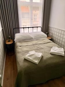 Un dormitorio con dos toallas en una cama con ventana. en Belvedere Old Town with Balcony AC Progres, en Toruń