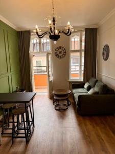 una sala de estar con un sofá y una mesa en Belvedere Old Town with Balcony AC Progres, en Toruń
