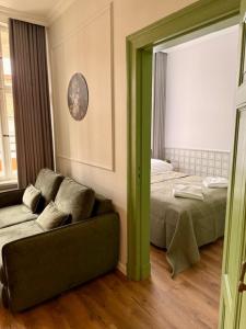 ein Wohnzimmer mit einer Couch und einem Bett und einem Spiegel in der Unterkunft Belvedere Old Town with Balcony AC Progres in Toruń