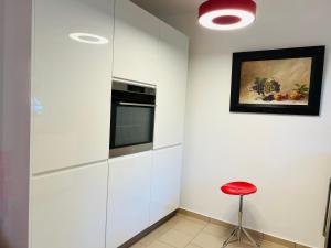 a kitchen with white cabinets and a red stool at Ferienhaus Schott Prichsenstadt in Prichsenstadt