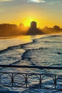 uma vista para uma praia com o pôr-do-sol em Casa Studio Mega - Reformado - Qto1 c Ar - 3 Vagas Garagem - Esp Térreo Priv - WiFi 300 Megas - Home Office a 200 mts Praia da Pompéia em Santos