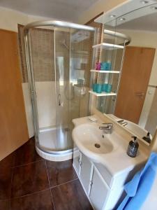 Un baño blanco con ducha y lavabo. en Bungalow in Kühlungsborn, en Kühlungsborn 5 fotos más