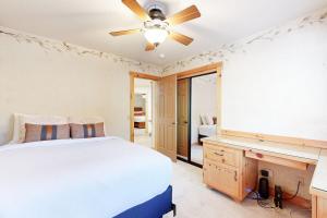 Un dormitorio con una cama, un escritorio y un ventilador de techo. en Stony Creek Retreat ~ Charming Mountain escape close to skiing, hiking, the lake, and the Village, en Big Bear Lake