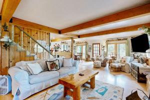 a living room with a couch and a table at Rooster's Den ~ Charming house with expansive deck, cable, internet, near Big Bear Lake in Big Bear Lake