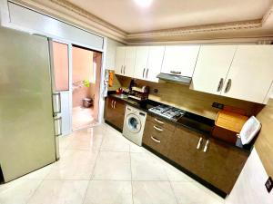 a kitchen with white cabinets and a washer and dryer at Marchica bay 20 holiday apartment in Nador