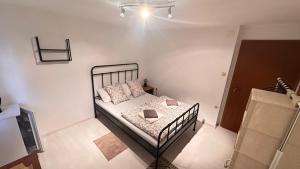 a bedroom with a bed in a white room at Room under Velika planina in Stahovica