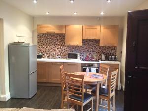 a kitchen with a table and a refrigerator at Ringinglow cottage in Sheffield
