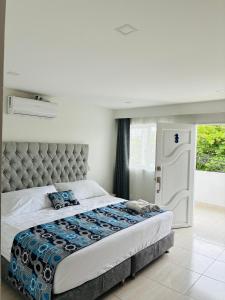 a bedroom with a large bed and a window at Mar de Indias House in Cartagena de Indias