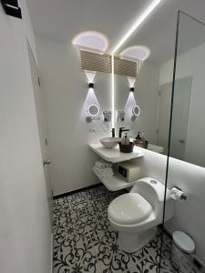 a bathroom with a toilet and a sink and mirrors at Casa Verde Hotel in Santa Marta +144 photos