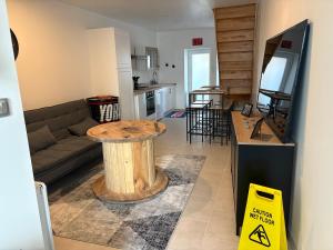 a living room with a table in the middle of a room at Appartement industriel in Corre