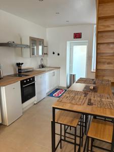 a kitchen with a table and chairs and an exit sign at Appartement industriel in Corre