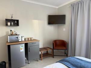 a bedroom with a desk with a microwave and a chair at Cozy NooK Mariental in Mariental