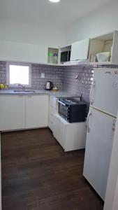 una piccola cucina con armadietti bianchi e frigorifero di Arequito centro a Arequito