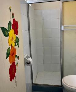 a bathroom with a shower with flowers painted on the wall at Habitación Charco Corazón in Jardin