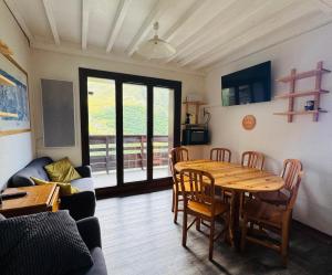 a living room with a wooden table and chairs at Les Menuires skis aux pieds in Les Menuires