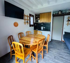 a dining room with a wooden table and chairs at Les Menuires skis aux pieds in Les Menuires