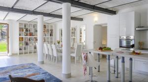 a kitchen with white columns and a table and chairs at Villa Denise in Mancini