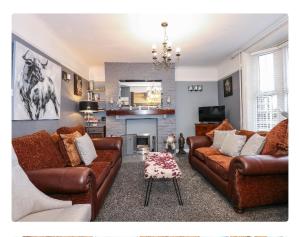 a living room with two brown couches and a fireplace at The Bays in Burgh le Marsh