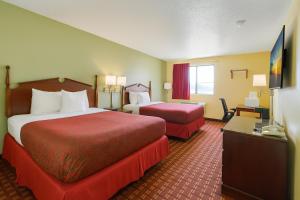a hotel room with two beds and a television at Days Inn by Wyndham Morton in Morton +16 photos