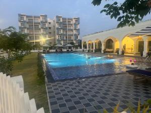 a large swimming pool in front of a building at UrbanEdge Negombo Resort Apartment in Negombo