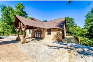 a home with a gambrel roof and a patio at Little Red River Chalet in Heber Springs