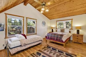 ein Schlafzimmer mit zwei Betten und einer Holzdecke in der Unterkunft Cub's Cabin / Charming 3-Bedroom Log Cabin Near Big Bear Lake in Big Bear Lake