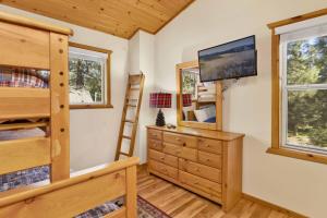 ein Schlafzimmer mit einem Etagenbett, einer Kommode und einem Fernseher in der Unterkunft Cub's Cabin / Charming 3-Bedroom Log Cabin Near Big Bear Lake in Big Bear Lake