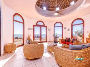 sala de estar con sillas, mesas y ventanas en Casa Serenity - Beachfront Vacation Rental in San Felipe, en Don Pancho