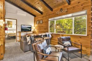 ein Wohnzimmer mit Stühlen und einem großen Fenster in der Unterkunft Orchard Family Cabin Near Historic Big Bear Village Walk to Marina in Big Bear Lake