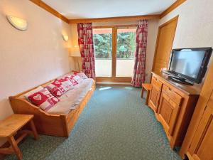 a small room with a bed and a television at Appartement 6 personnes - Les Menuires, vue montagne - FR-1-452-111 in Les Menuires