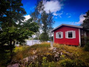 a red house on top of a hill with trees at Roparudden in Kvicksund