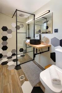a bathroom with a sink and a toilet and a mirror at Meraki Apartment by PaxosRetreats in Longos