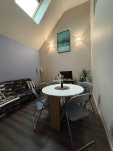 a room with a table and chairs and a window at Le magnolia in Épieds