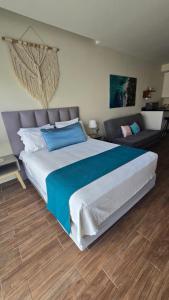 a bedroom with a large bed and a couch at Umbral Estudio 203 Wi-Fi Rápido Oasis Urbano in Playa del Carmen