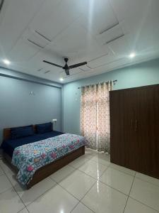 Un dormitorio con una cama y un ventilador de techo. en Diya Apartment, en Rishīkesh