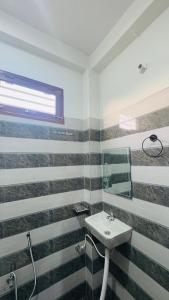 Un baño con lavabo y ventana. en Diya Apartment, en Rishīkesh