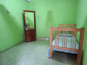 a bedroom with a wooden bed and a mirror at Tk Homestay in Talawakele