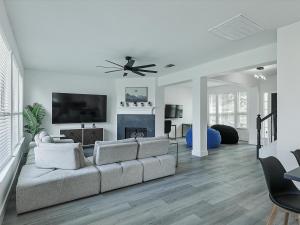 a living room with a couch and a flat screen tv at Newly Renovated Luxury 5BR Spacious, Stylish, Family-Ready in The Colony