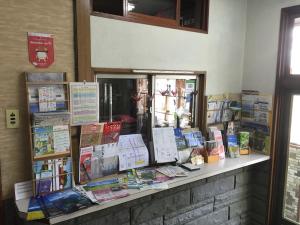 a counter with a bunch of books on it at Mimatsuso Ryokan in Asahikawa