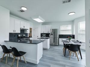 a kitchen with white cabinets and a table and chairs at Newly Renovated Luxury 5BR Spacious, Stylish, Family-Ready in The Colony