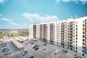 a large white building with cars parked in a parking lot at 1BR Yas Marina Apartment - Near Ferrari World in Abu Dhabi